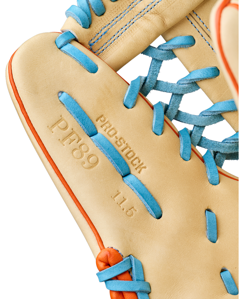 Close-up of a Wilson A2000 PF89 11.5" Baseball Glove (WBW104602115) featuring tan Pro Stock leather, blue laces, orange stitching, and palm embossing reading Pedroia Fit, PRO STOCK, P.F. 89, and 11.5.
