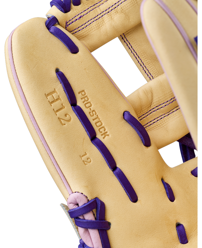 Close-up of a tan Wilson A2000 H12 12" Fastpitch Glove (WBW10460712) with purple laces and stitching. The infield glove features PRO STOCK, H12, and 12 stamped on the palm, showcasing premium Pro Stock Leather.