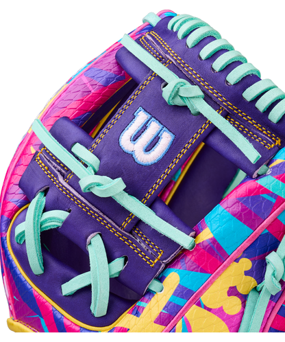 Close-up of the Wilson A2000 1786SS 11.5" GOTM January 2026 glove, crafted with Pro Stock leather in pink, purple, yellow, and teal patterns, light blue laces, and a white W logo on a purple background.
