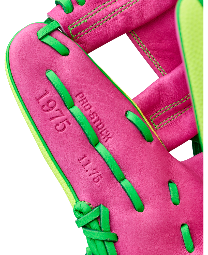 Close-up of the Wilson A2000 1975SS 11.75" Baseball Glove (GOTM March 2026) in pink leather with bright green laces, featuring "1975," "PRO-STOCK," and "11.75" embossed on the palm.