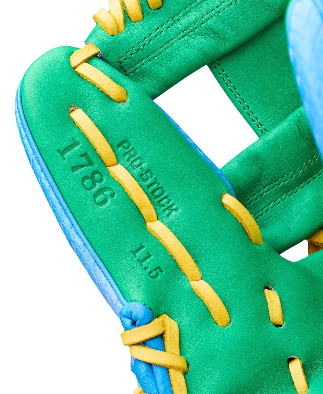 Close-up of the Wilson Love the Moment A2000 1786SS 11.5" Noah’s Edition glove—green with yellow laces and blue edges, stamped 1786, PRO STOCK, and 11.5; part of the Autism Speaks collaboration.