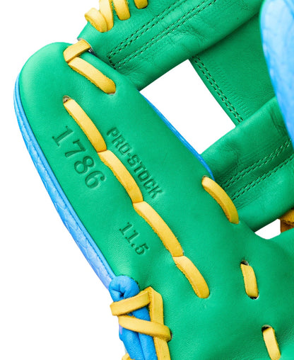 Close-up of the Wilson Love the Moment A2000 1786SS 11.5" Noah’s Edition glove—green with yellow laces and blue edges, stamped 1786, PRO STOCK, and 11.5; part of the Autism Speaks collaboration.