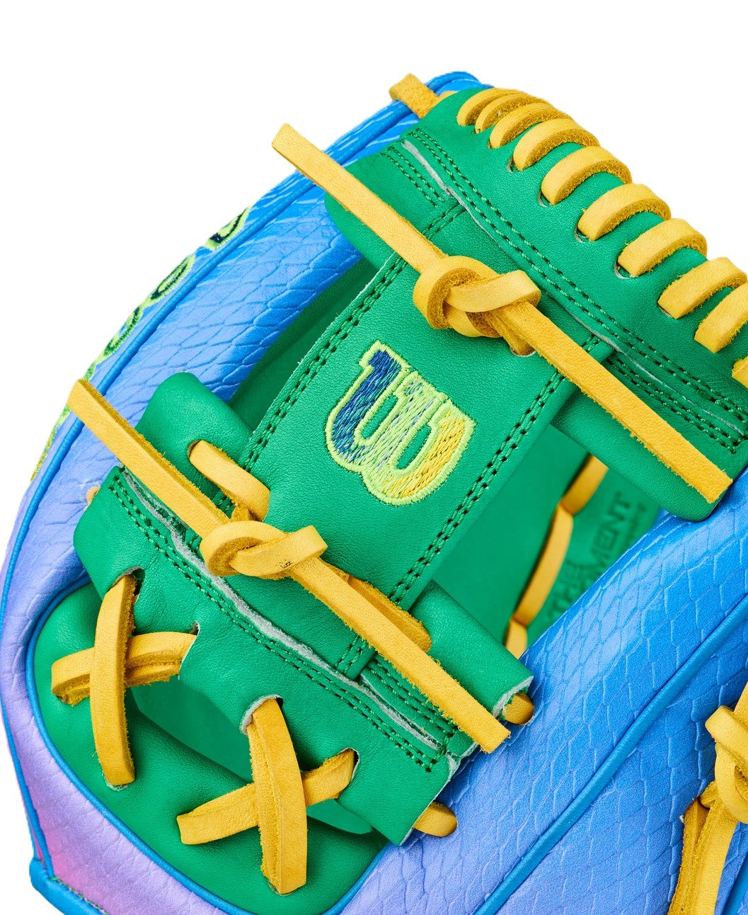 Close-up of the Wilson Love the Moment A2000 1786SS 11.5" Noah’s Edition Baseball Glove (WBW104826115), showing green, blue, and purple leather, yellow laces, a stitched W logo, and created with Autism Speaks.