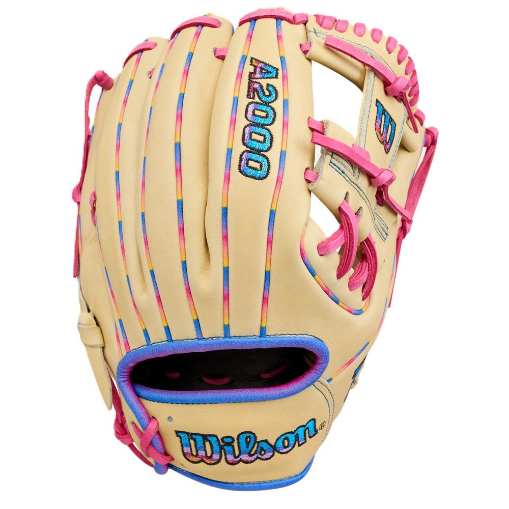 The Wilson Love the Moment A2000 1786 11.5" Baseball Glove (WBW104827115) features a tan design with pink laces, blue trim, multicolored stitching, and blue and pink embroidered Wilson logos. Crafted from durable Pro Stock Leather.