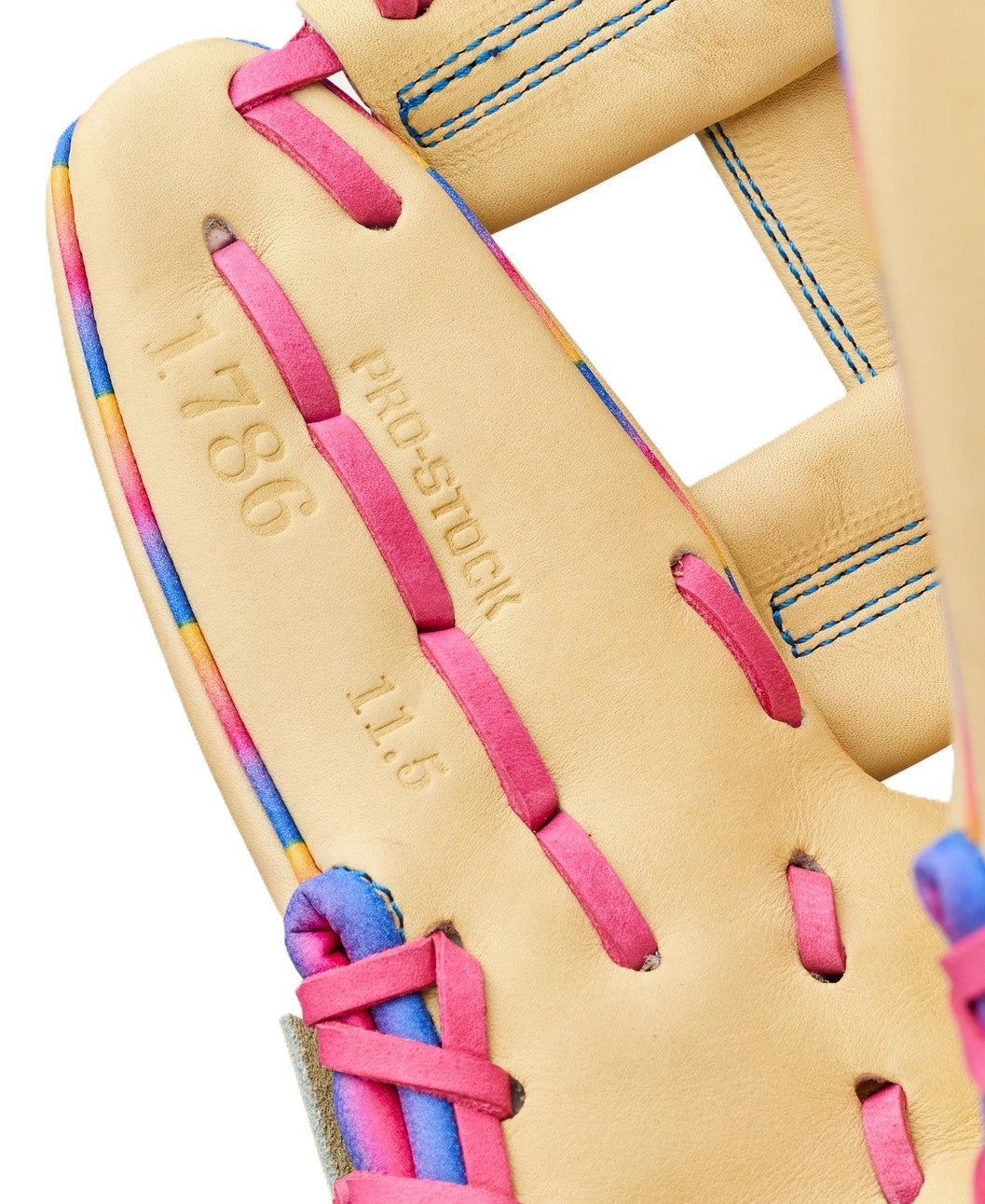 Close-up of a tan Wilson Love the Moment A2000 1786 11.5" infield glove with pink laces, colorful trim, blue stitching, and "1786," "PRO-STOCK," and "11.5" stamped on the leather—an Autism Speaks edition.