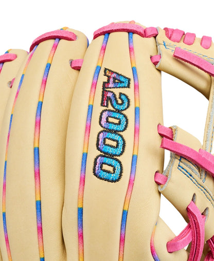 A close-up of the Wilson Love the Moment A2000 1786 11.5" baseball glove, featuring tan Pro Stock Leather with pink laces and blue, pink, and yellow accents. The A2000 model number is stitched in multicolored thread on the glove.