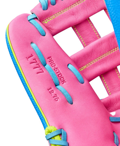 Close-up of the Wilson Love the Moment A2000 1777 12.75" baseball glove in pink with blue and yellow stitching, featuring PRO STOCK, 12.75, and 1777 in red on the palm—a nod to Autism Speaks design.
