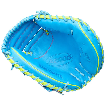 The Wilson Love the Moment A2000 CM33SS 33" Baseball Catcher's Mitt (WBW10483533) is a bright blue mitt with yellow laces and pink stitching, crafted from Pro Stock Leather and featuring visible brand markings inside.