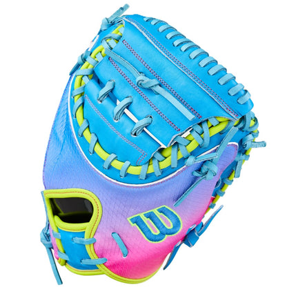 The Wilson Love the Moment A2000 CM33SS 33" Catcher’s Mitt features a vibrant blue, pink, and yellow gradient with blue laces, a “W” logo near the thumb, and is crafted from durable Pro Stock Leather.