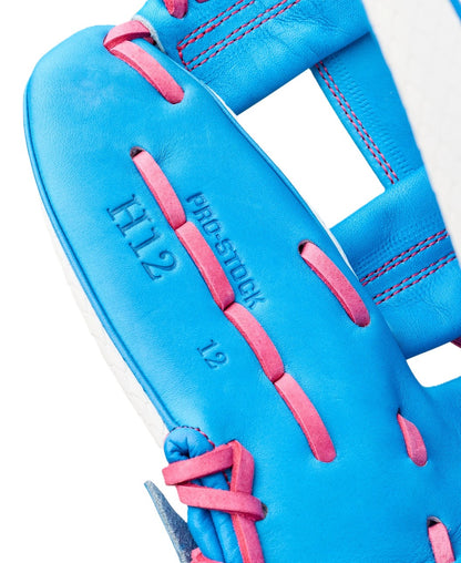 Close-up of the Wilson Love the Moment A2000 H12SS 12" Fastpitch Glove (WBW10483612) in blue with pink laces, featuring "H12," "PRO-STOCK," and "12" stamped on the inner palm area.