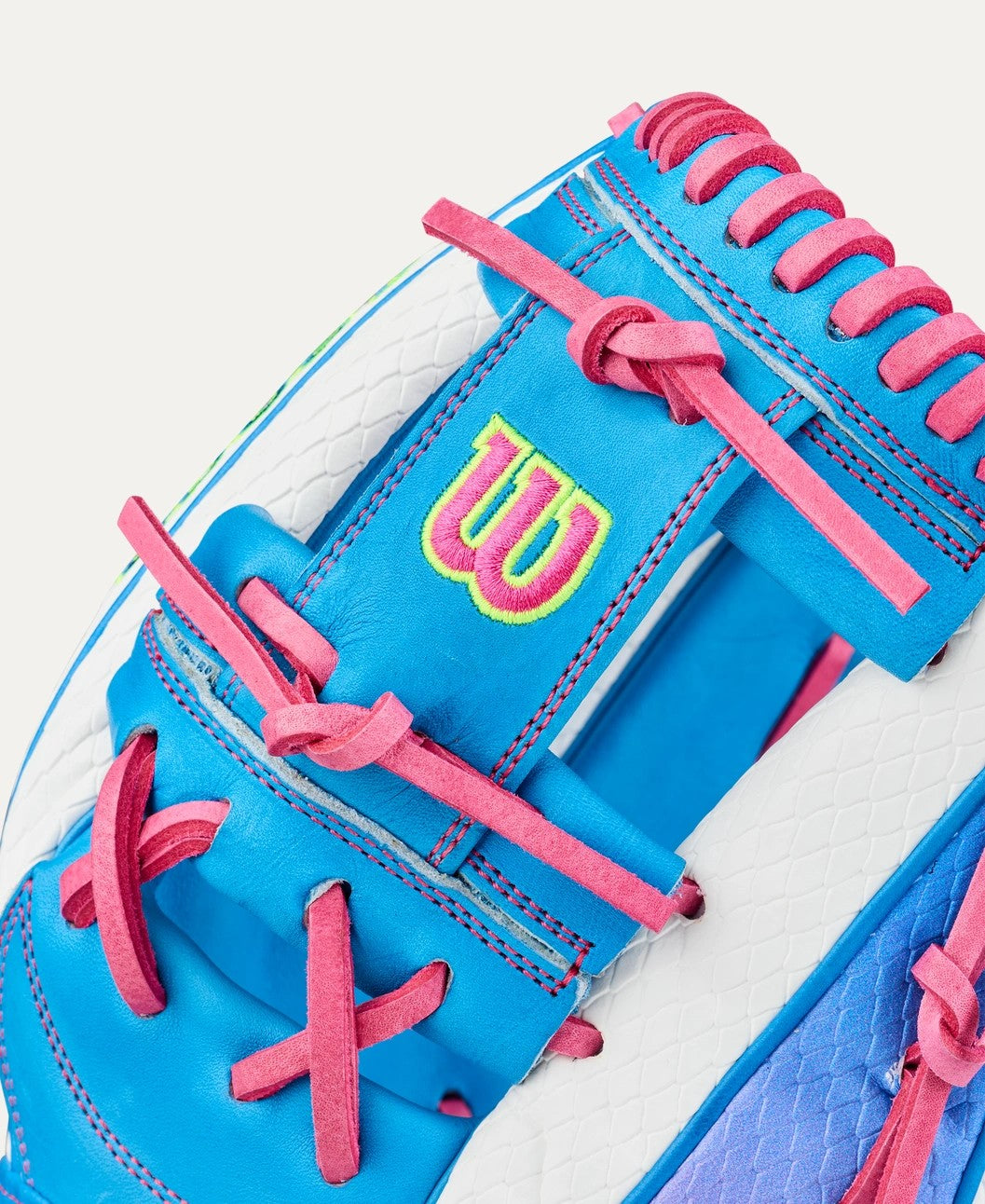 Close-up of the Wilson Love the Moment A2000 H12SS 12" Fastpitch Glove, showcasing blue leather, pink laces, white accents, and a neon yellow W logo on the wrist strap.