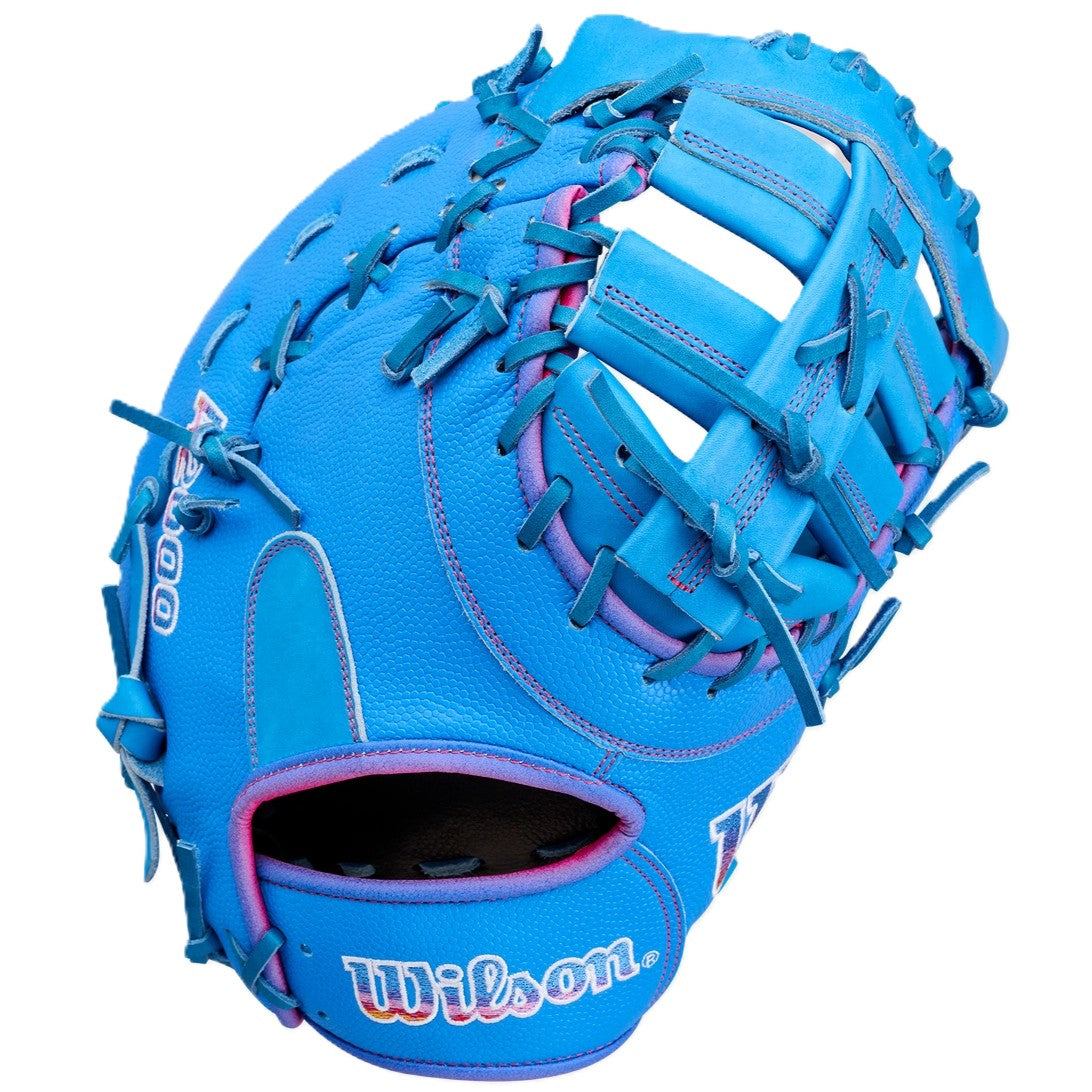 The Wilson Love the Moment A2000 1612 12" First Base Mitt (WBW10483812) features bright blue Pro Stock Leather, pink accents and lacing, an open web design, and the Wilson logo embroidered on the wrist strap.