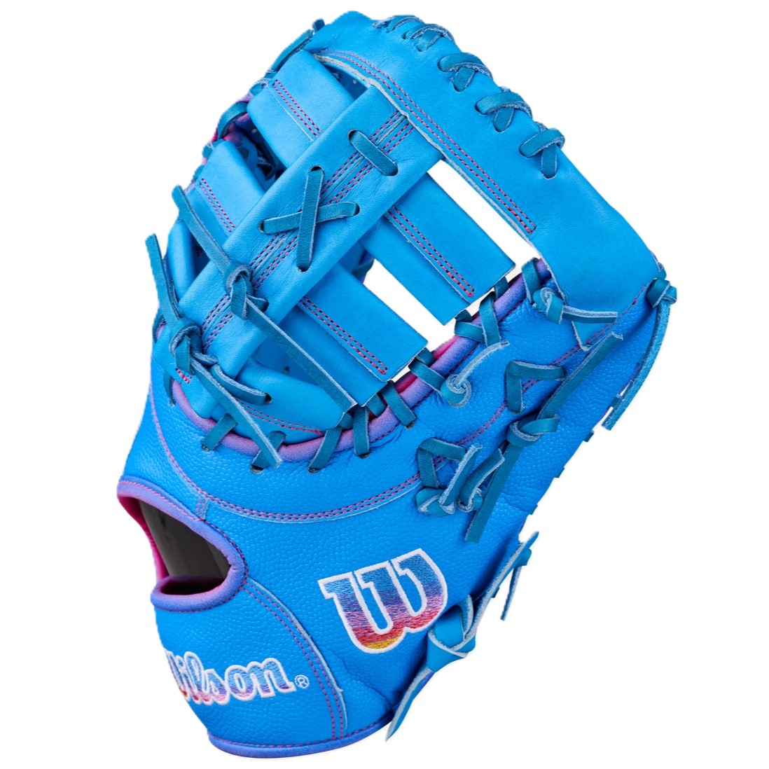 The Wilson Love the Moment A2000 1612 12" First Base Mitt (WBW10483812) features a bright blue design with pink and purple stitching, open web, Pro Stock Leather, and a multicolored Wilson W logo on the side.
