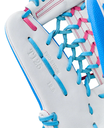 Close-up of the Wilson Love the Moment A2000 T125SS 12.5" Fastpitch Glove, featuring white leather with blue and pink laces, Autism Speaks-inspired colors, "PRO STOCK," "A2000," and "12.5" stamps in detailed stitching.