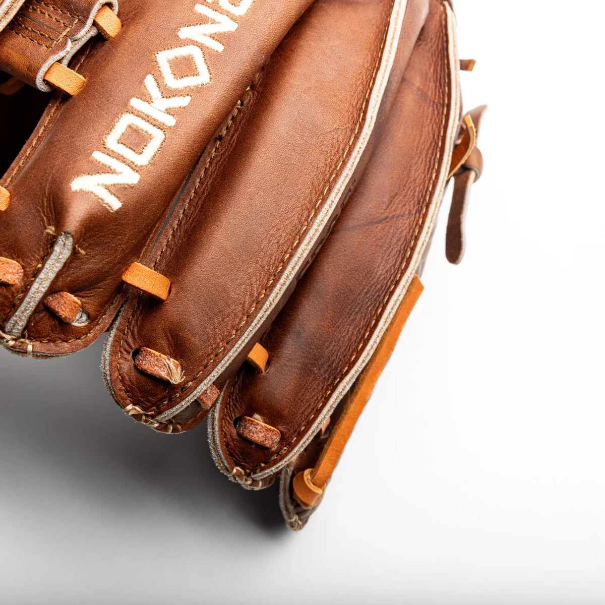 Close-up of the fingers of a handcrafted Nokona Walnut EP 11.75″ Baseball Glove: W-EP1175, showing the rich brown leather and intricate lacing.
