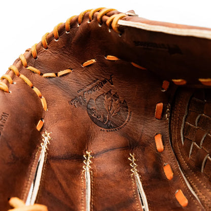 Close-up of a handcrafted Nokona Walnut EP 12″ Baseball Glove: W-EP1200 with orange lacing and a circular embossed logo in the palm.