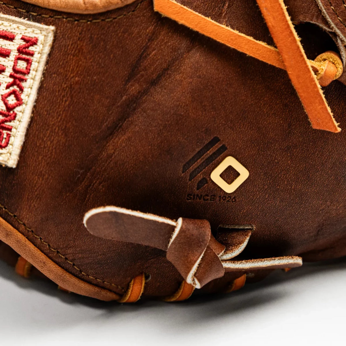 Close-up of a handcrafted Walnut Crunch Nokona Walnut EP 12″ Baseball Glove: W-EP1200, featuring a logo with a square and three lines above the text SINCE 1926 stamped into the leather.