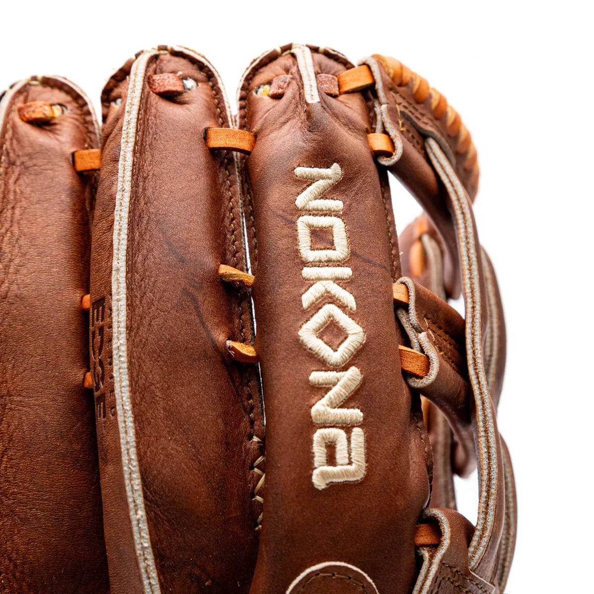 Close-up of a handcrafted Nokona Walnut EP 12.75″ Baseball Glove: W-EP1275 made of brown leather, with the brand name embroidered vertically in white thread.