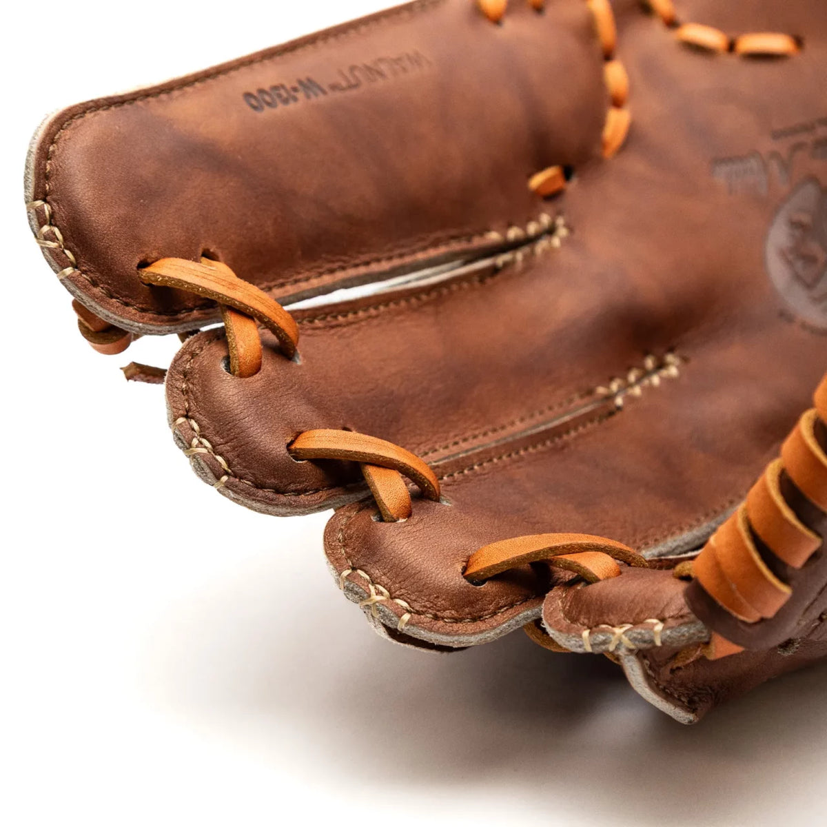 Close-up of a brown Walnut Crunch Nokona Walnut EP 13″ Baseball Glove: W-EP1300C showing the laced webbing between the fingers.