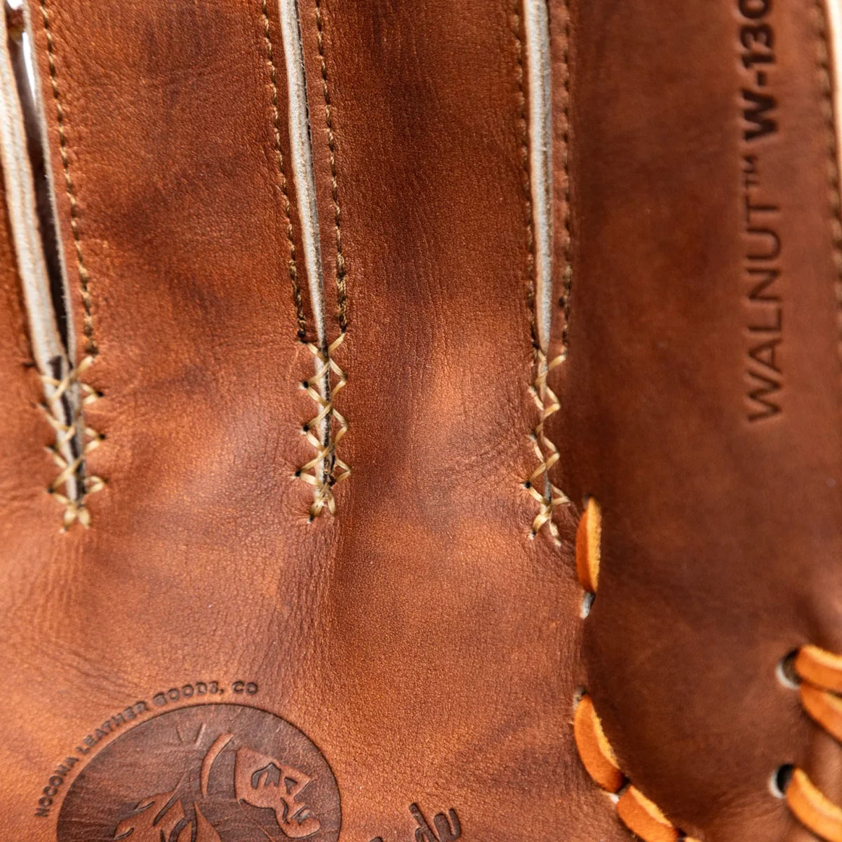 Close-up of the Walnut Crunch leather palm and finger lacing on a Nokona Walnut EP 13″ Baseball Glove: W-EP1300C, featuring a debossed logo and model name stamped on the side.