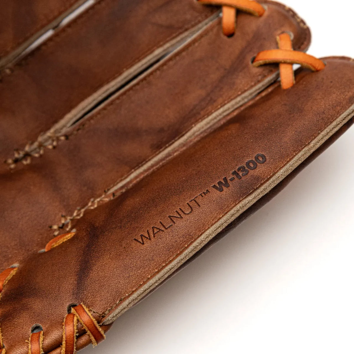 Close-up of a brown Nokona Walnut EP 13″ Baseball Glove: W-EP1300H with tan lacing, stamped with WALNUT W-1300 on the side.