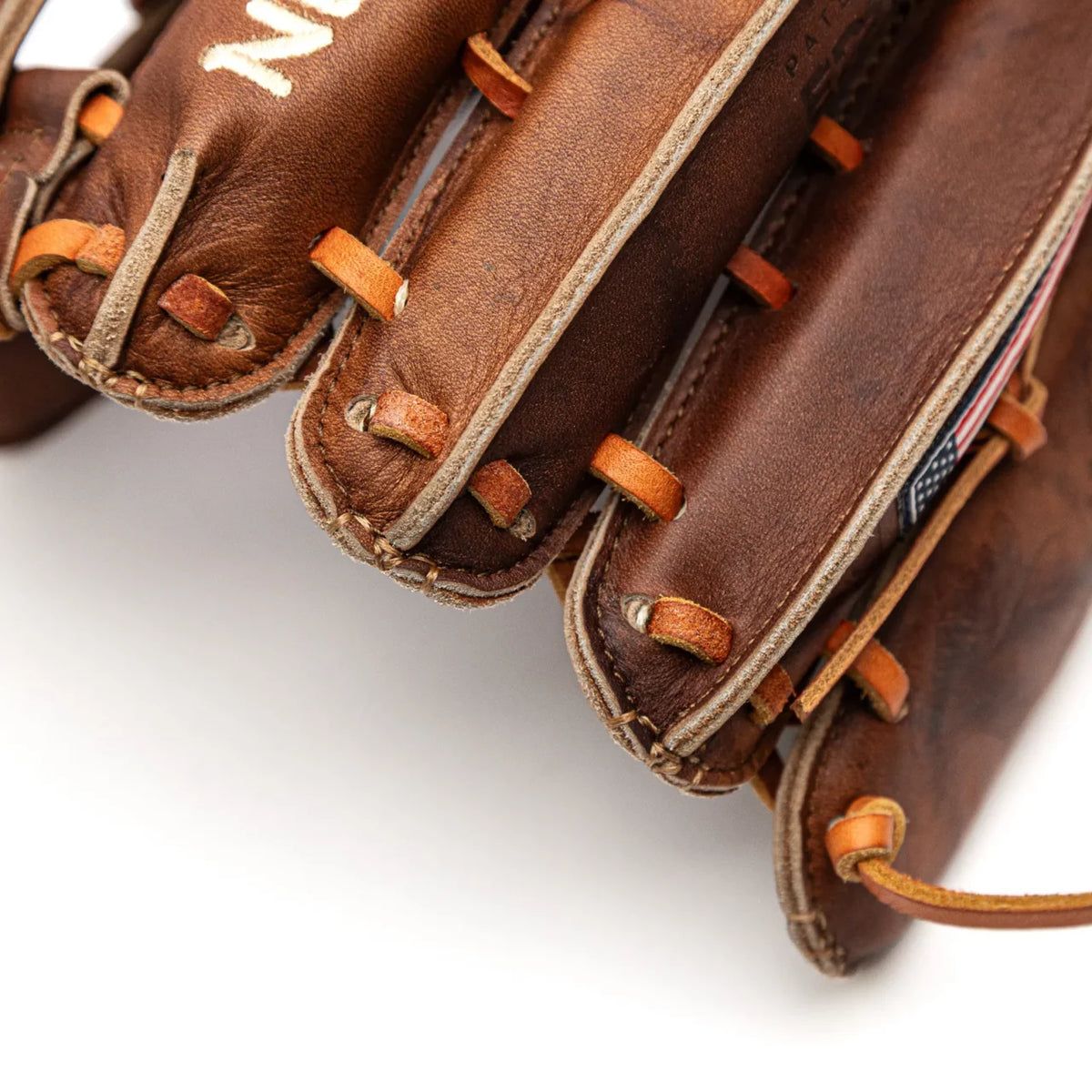 Brown Nokona Walnut EP 13″ Baseball Glove: W-EP1300H outfield glove with orange laces and a small American flag patch.