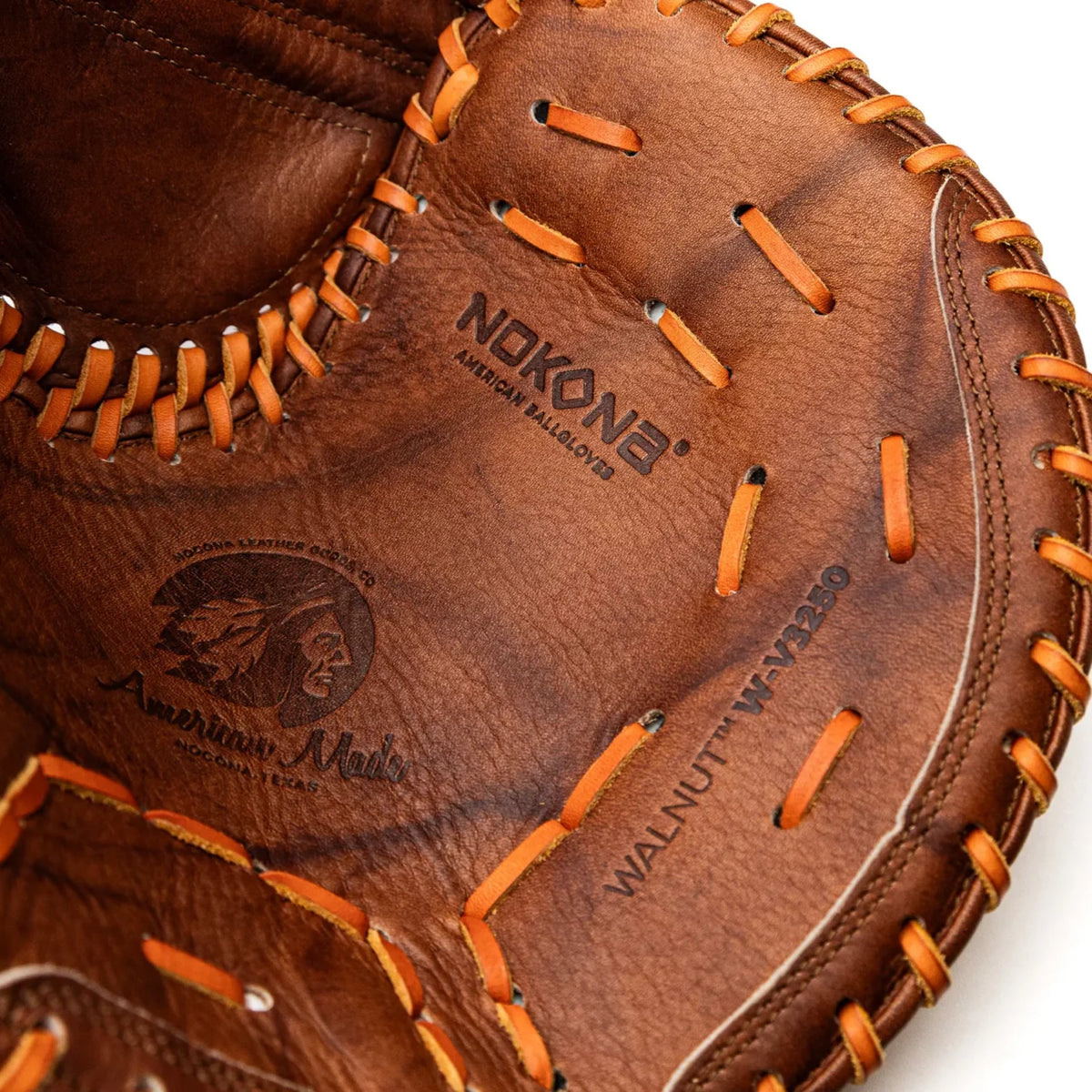 Close-up of a Nokona Walnut EP 32.5″ Fastpitch Catcher’s Mitt: W-EPV3250, featuring Walnut Crunch leather, orange lacing, and embossed branding stamps.