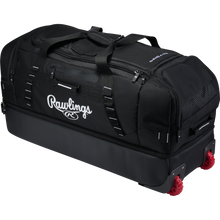 Large black Rawlings Yadi 2 Luggage Wheeled Catcher’s Bag with red wheels and multiple external storage compartments.