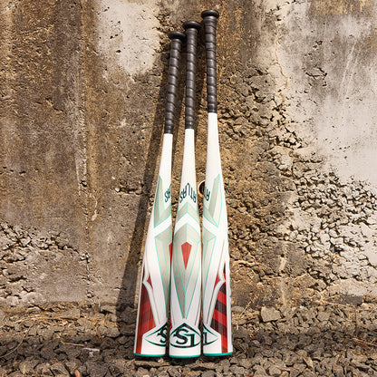 Three Louisville Slugger Atlas (-5) 2 5/8" USSSA Baseball Bats (WBL2981010) stand upright, featuring white barrels, black handles, and geometric green, red, and gray designs against a textured concrete wall.
