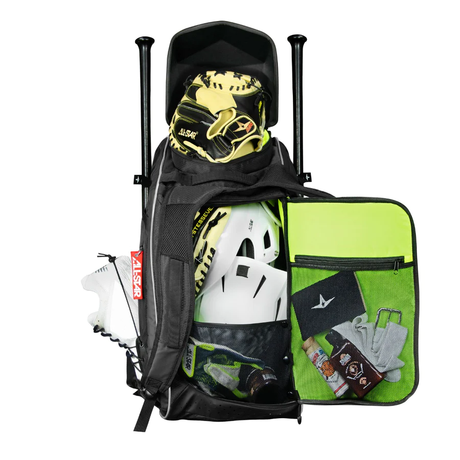 A black and neon green sports equipment bag is open, showing a baseball glove, helmet, cleats, bats, and organized accessories in mesh pockets in the front flap.
