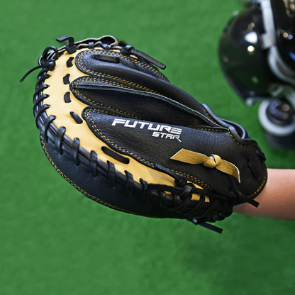 A close-up of the All Star Future Star 31.5" Baseball Catcher's Mitt (CM-FS-Y) in black and tan, featuring lightweight construction, held open on green turf with other catcher's gear visible in the background.