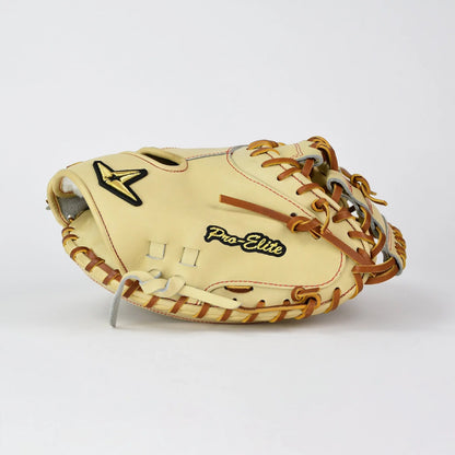 An All Star Pro-Elite Japan 34″ Baseball Catcher’s Mitt (CM3000-J2-34) with tan HIMEJI leather, brown laces, and “Pro-Elite” stitched in gold lettering rests on a plain white surface, highlighting the craftsmanship and Japanese-inspired design of this All Star Pro-Elite Japan Series mitt.