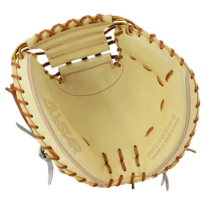 A tan All Star Pro-Elite Japan 34″ Baseball Catcher’s Mitt (CM3000-J2-34), crafted from HIMEJI leather with brown laces, features the ALL STAR logo and Japanese text printed on the palm. The mitt is open, displaying its deep pocket and robust construction.