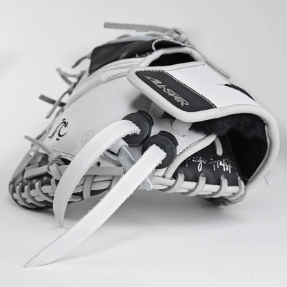 A close-up of the All Star PHX 33″ Paige Halstead Fastpitch Catcher’s Mitt (CMW-PHX-33) in white and black, with visible laces and All Star branding, showcases its adjustable pocket system for a custom travel ball fit against a plain white background.