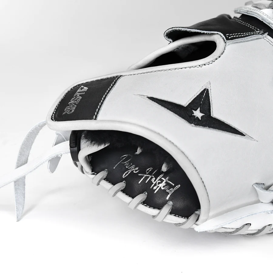 A close-up of the All Star PHX 34" Paige Halstead GM Fastpitch Catcher's Mitt, crafted from premium leather with a black and white design, featuring the All Star logo and Paige Halstead's signature stitched on the palm.