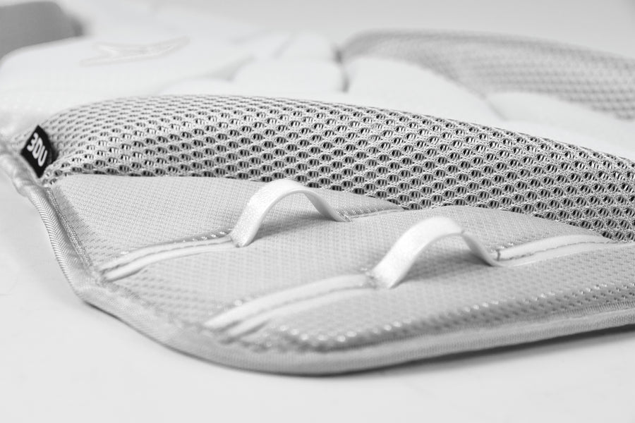 Close-up of a white and gray padded mesh fabric with two white loops and detailed stitching from the All Star PHX Paige Halstead Fastpitch Catcher's Chest Protector: CPW-PHX by All Star, shown on a plain background.