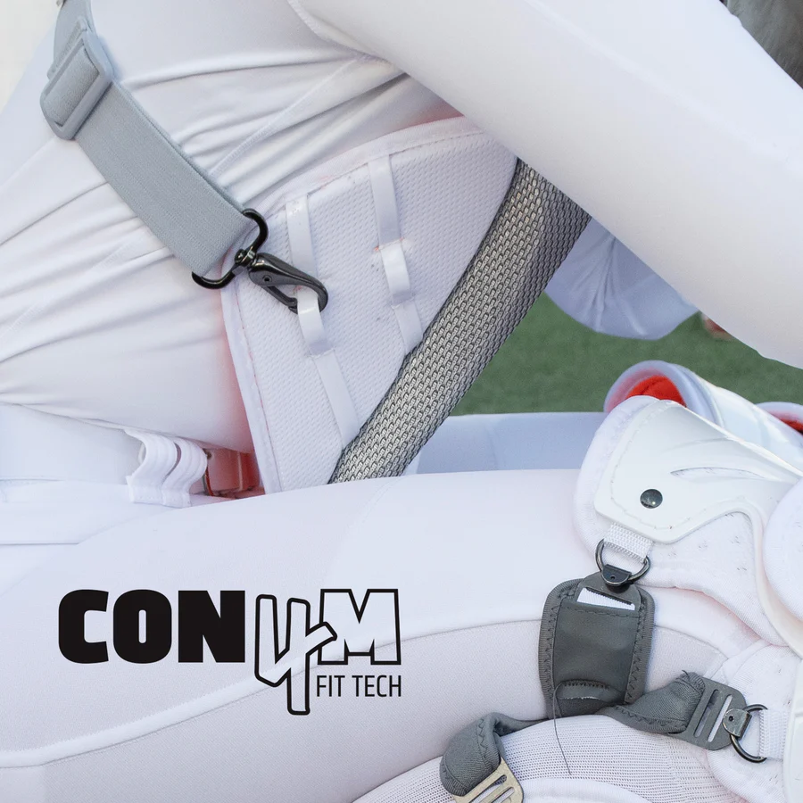 A close-up shows a person in white athletic gear wearing the All Star PHX Paige Halstead Fastpitch Catcher's Chest Protector (CPW-PHX), featuring secure clips and the Con4m Fit Tech logo, endorsed by catcher Paige Halstead.