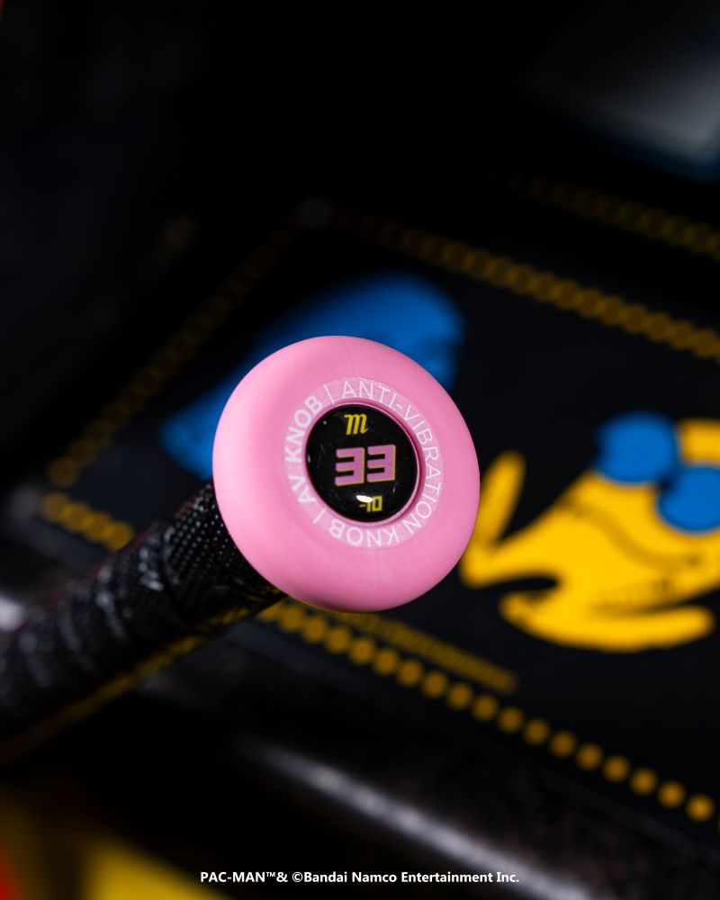Close-up of the Marucci 2027 ASURA Rise PAC-MAN (-10) Fastpitch Softball Bat, featuring a pink circular ANTI-VIBRATION KNOB with "33", Rise Sync Barrel Technology, and a blurred yellow Pac-Man ghost on a black background.