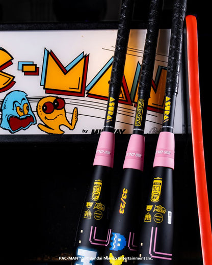 Three Marucci 2027 ASURA Rise PAC-MAN (-10) Fastpitch Softball Bats with black barrels and pink handles, featuring Rise Sync Barrel Technology, are propped against a vintage PAC-MAN Collection arcade game displaying Pac-Man and a blue ghost.