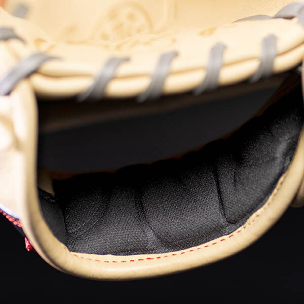 Close-up of the inside palm area of a beige baseball glove, showing black padded lining and some grey lacing with visible stitching details.