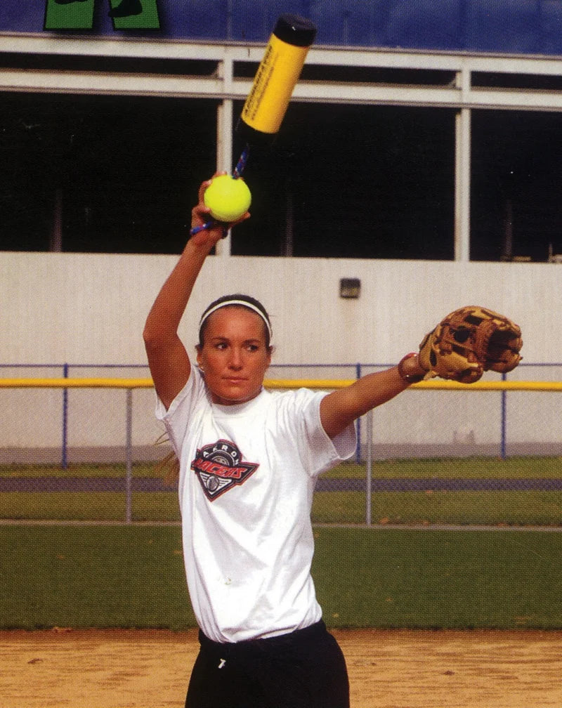 A softball pitcher practicing her windup and wrist snap while holding a yellow Markwort Xelerator Fastpitch Pitching Trainer: MWXELERFP attached to a ball.