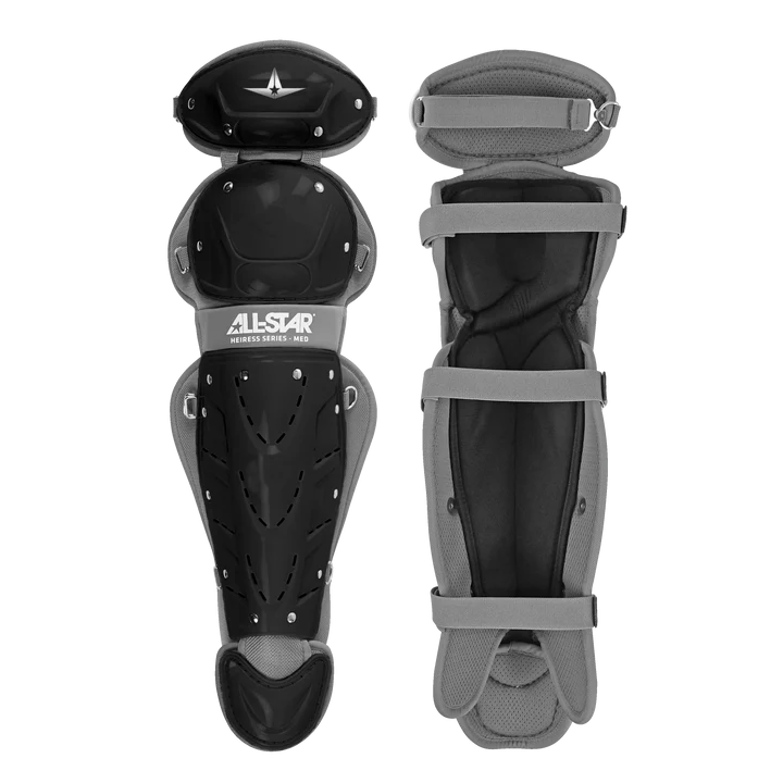 Two black and gray All Star Heiress Fastpitch Catcher's Kit leg guards are shown—one displays the hard shell with ventilation holes and All Star branding; the other reveals padded lining and adjustable straps.