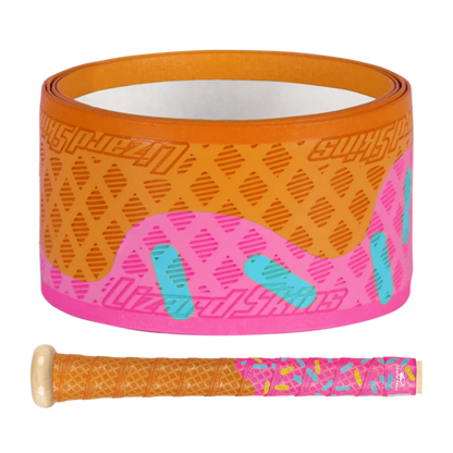 The Lizard Skins DSP Ultra Outburst 1.1mm Bat Grip in Pink Scoop features a donut-inspired tan base, pink top, and blue sprinkles. Made by Lizard Skins from durable polymer, it's shown both rolled up and wrapped on a bat handle.