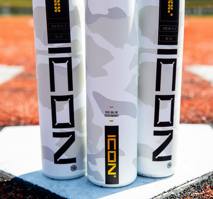 A group of white objects on a field features the 2025 Rawlings Icon (-5) 2 3/4" USSSA Baseball Bat (RUT5I5), standing out with its sleek carbon composite design from Rawlings.