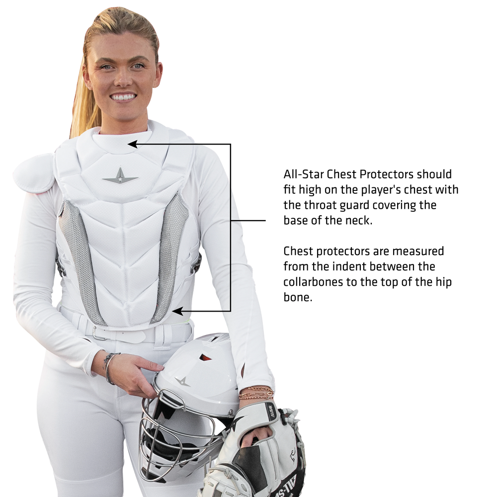 Wearing the All Star PHX Paige Halstead Fastpitch Catcher's Chest Protector (CPW-PHX), a catcher holds her mask. A text box shares tips from Paige Halstead on fitting and placing the chest protector for proper chest and neck coverage.