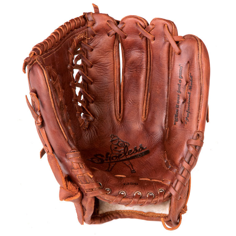 A well-worn Shoeless Joe 12.5" Baseball Glove (model 1250TT) in brown leather features visible stitching and lacing, shown open to display the palm side with the Shoeless Joe logo and model details inside.