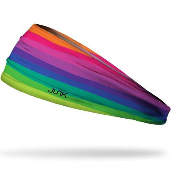 The Junk Crayon Cove Headband by Junk features horizontal rainbow stripes with "JUNK" in black on the green stripe, crafted from moisture-wicking fabric and shown against a white background.
