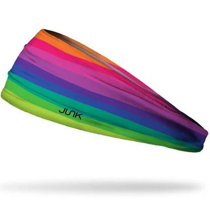 The Junk Crayon Cove Headband by Junk features horizontal rainbow stripes with "JUNK" in black on the green stripe, crafted from moisture-wicking fabric and shown against a white background.