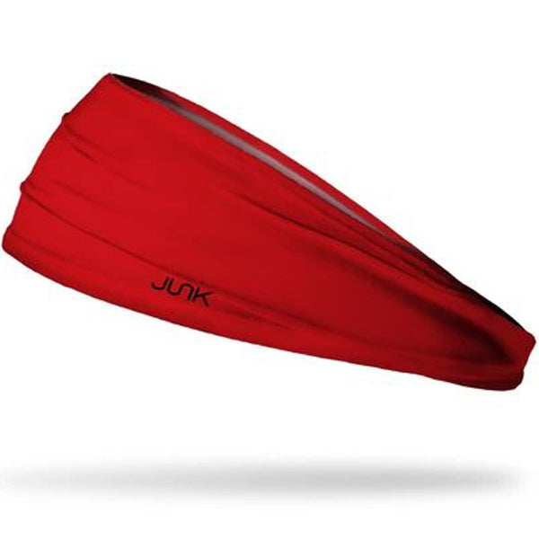 The Junk True Red Headband by Junk is a bright red, moisture-wicking athletic headband with a slight twist design and "JUNK" printed in black on the side, shown on a white background.