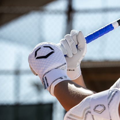 A person holding a baseball bat while wearing the EvoShield PRO-SRZ 2.0 Batter's Hand Guard (WB5726801) for maximum protection at the plate.